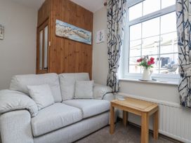 A living room with a sofa and wooden table at Chapel Cottage in Filey