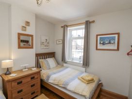 A bedroom with a bed and nightstand at Chapel Cottage in Filey
