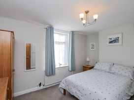 A bedroom with a bed and wardrobe at Chapel Cottage in Filey