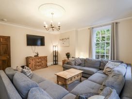 A living room with a sectional sofa and television at The Manor House in Scarborough