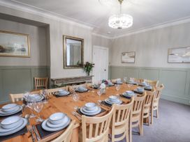 A dining room with a large table set for a meal at The Manor House in Scarborough
