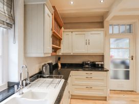 A kitchen with cabinets, a sink, and appliances at The Manor House in Scarborough
