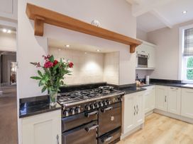 A kitchen with an oven and flowers on the countertop at The Manor House in Scarborough