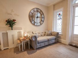 A living room with a sofa and a mirror at The Manor House in Scarborough