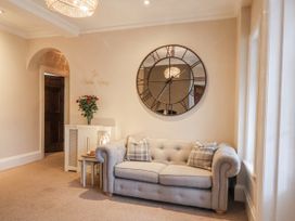 A living room with a sofa and clock at The Manor House in Scarborough