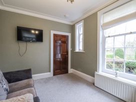 A living room with a television and sofa at The Manor House in Scarborough