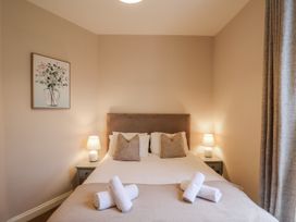 A bedroom with a bed, lamps, and a picture at The Manor House in Scarborough