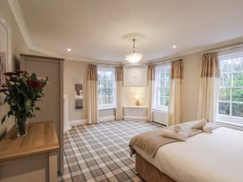 A bedroom with a bed and windows at The Manor House in Scarborough