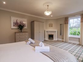 A bedroom with a bed, wardrobe, and window at The Manor House in Scarborough