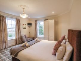 A bedroom with a bed and a chair at The Manor House in Scarborough