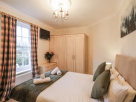 A bedroom with a bed and wardrobe at The Manor House in Scarborough