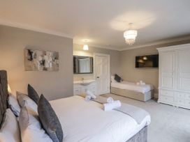 A bedroom with beds and a wardrobe at The Manor House in Scarborough