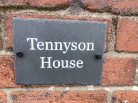 A sign on a brick wall reading Tennyson House in Scarborough