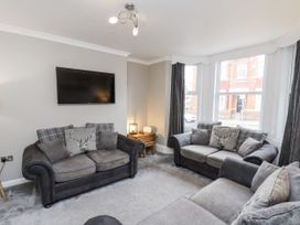 A living room with a sofa and television at Tennyson House in Scarborough