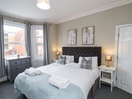 A bedroom with a bed and side tables at Tennyson House in Scarborough