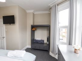 A bedroom with a television and wardrobe at Tennyson House in Scarborough