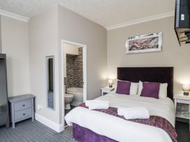 A bedroom with a bed and a bathroom door at Tennyson House in Scarborough