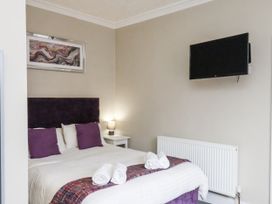 A bedroom with a bed and television at Tennyson House, Scarborough