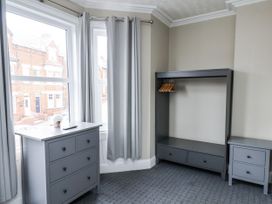 A bedroom with a dresser and a clothes rack at Tennyson House in Scarborough