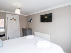 A bedroom with a bed and television at Tennyson House in Scarborough