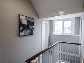 A hallway with a staircase and a painting at Tennyson House in Scarborough