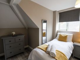A bedroom with a bed and dresser at Tennyson House in Scarborough
