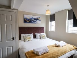A bedroom with a bed and wall art at Tennyson House in Scarborough