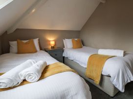 A bedroom with two beds and a lamp at Tennyson House in Scarborough
