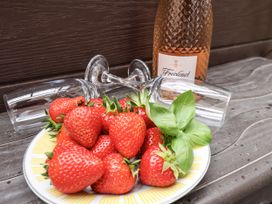 A plate of strawberries with wine glasses and a bottle at Tennyson House in Scarborough