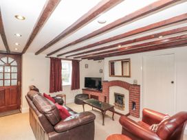 A living room with a TV and fireplace at Dove Cottage in Sleights