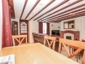 A living room with a dining table and sofa at Dove Cottage in Sleights