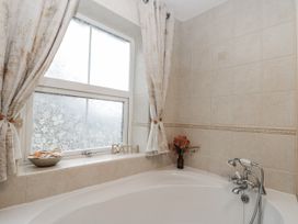 A bathroom with a bathtub and a window at Dove Cottage in Sleights