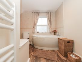 A bathroom with a bathtub and toilet at Dove Cottage in Sleights