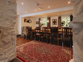 A dining room with a long table and chairs at Cwmalis Hall Llangollen