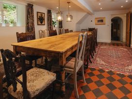 A dining room with a large table and chairs at Cwmalis Hall in Llangollen