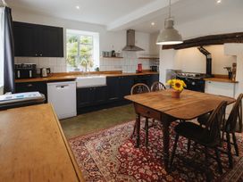 A kitchen with a table and chairs at Cwmalis Hall in Llangollen