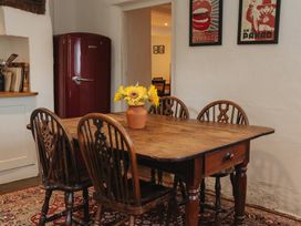 A dining room with a wooden table and chairs at Cwmalis Hall in Llangollen