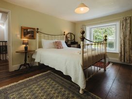 A bedroom with a bed and lamp at Cwmalis Hall Llangollen