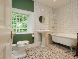 A bathroom with a bathtub, sink, and toilet at Cwmalis Hall in Llangollen