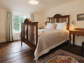 A bedroom with a wooden bed and nightstand at Cwmalis Hall in Llangollen