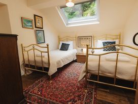 A bedroom with two beds and window at Cwmalis Hall in Llangollen