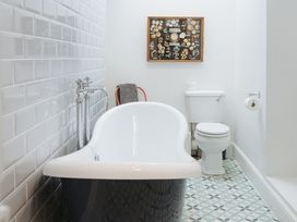 A bathroom with a bathtub and toilet at Cwmalis Hall in Llangollen