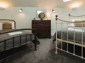 A bedroom with two beds and a dresser at Cwmalis Hall Llangollen