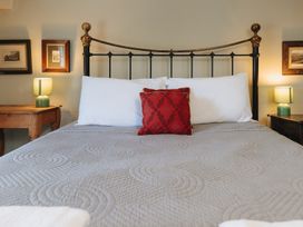 A bedroom with a bed and bedside tables at Cwmalis Hall Llangollen