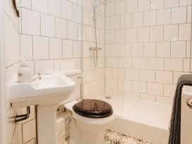 A bathroom with a shower, sink, and toilet at Cwmalis Hall Llangollen