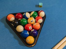 A triangular rack of billiard balls on a pool table