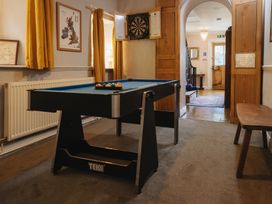 A game room with a pool table and darts board at Cwmalis Hall in Llangollen