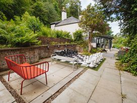 A garden with a large chess set and seating area at Cwmalis Hall in Llangollen