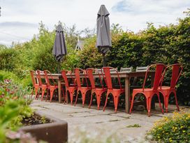 An outdoor dining area with a table and chairs at Cwmalis Hall in Llangollen