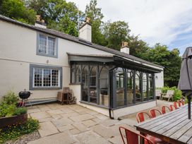 A conservatory attached to a house with a table and chairs at Cwmalis Hall Llangollen